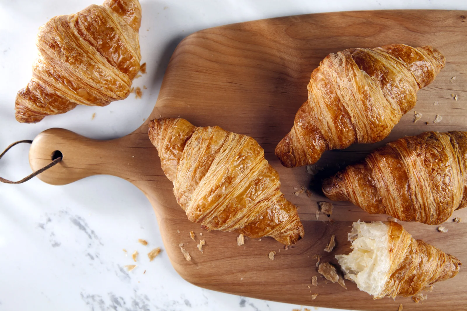 Fresh Bonjour butter croissants served on a wooden board