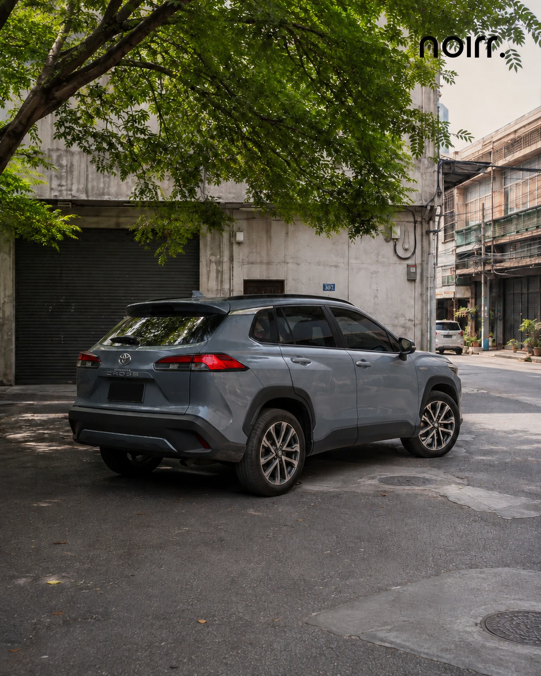 Toyota Corolla Cross complete rear three quarter portrait in a Bangkok courtyard