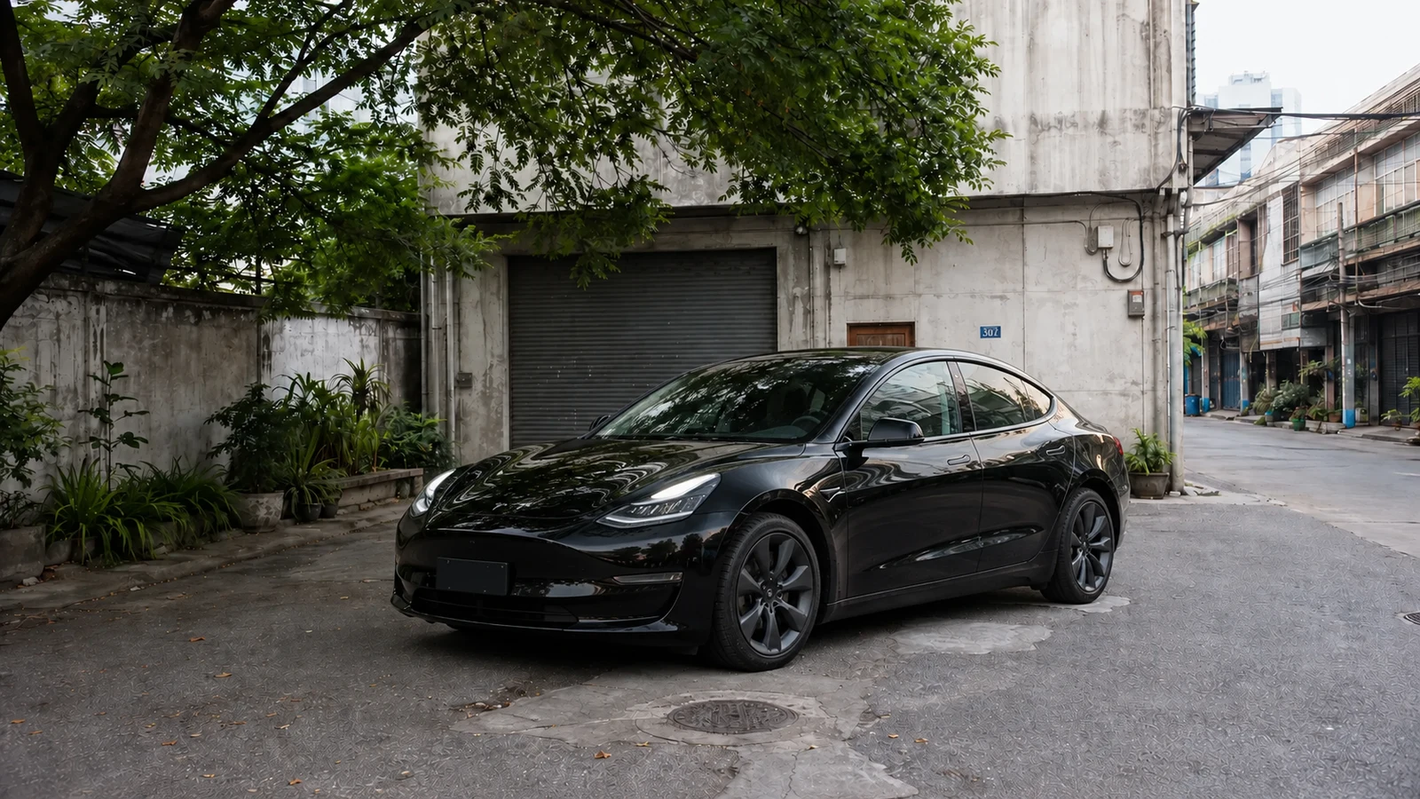 Tesla Model 3 front three quarter in the Charoen Krung courtyard during daytime